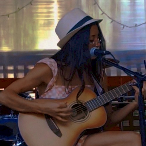 Bre Gonzalez singing and playing acoustic guitar during Beats & Bites Brunch at Riverhouse Lodge Bend Oregon.