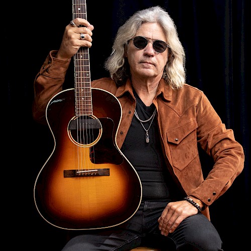 Americana singer songwriter Dean Mueller performing acoustic guitar during Beats and Bites brunch at Riverhouse Lodge Bend Oregon.