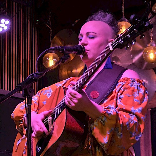 Gina DeNoble performing live acoustic folk music during Beats & Bites Brunch at Currents Restaurant in Bend Oregon
