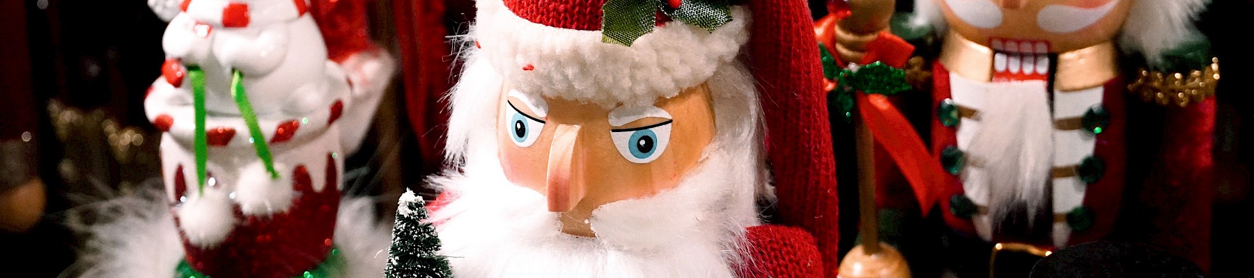 Colorful Christmas ornaments, including Santa, nutcracker, snowman, and elves, are displayed as festive decorations.