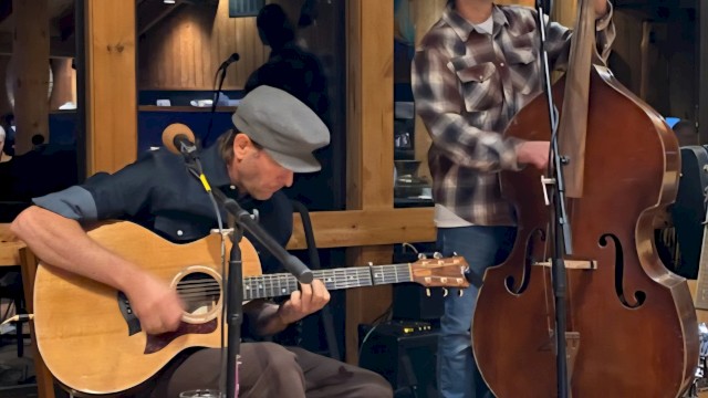 Two folk musicians performing live with acoustic guitar and upright bass during a brunch performance at Currents at Riverhouse Lodge, a riverfront live music venue in Bend, Oregon.