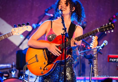 Female singer-songwriter performing live with electric guitar and microphone during Beats & Bites Brunch at Currents at Riverhouse Lodge in Bend, Oregon.