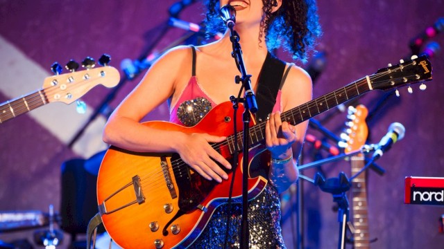 Female singer-songwriter performing live with electric guitar and microphone during Beats & Bites Brunch at Currents at Riverhouse Lodge in Bend, Oregon.
