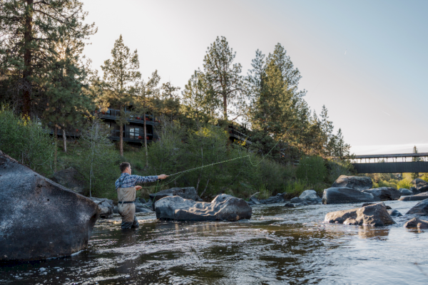 Fly fishing on the Deschutes River at Riverhouse Lodge in Bend, Oregon, featuring Benchmark Spring Escape savings—up to 30% off and $50 food and beverage credit when booked Feb 20–Mar 6, 2026.
