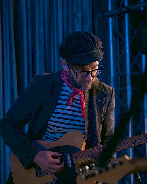 Singer-songwriter Chris Beland playing acoustic guitar during Live Music Fridays at Currents Restaurant in Riverhouse Lodge, Bend Oregon.
