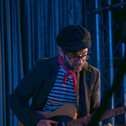 Singer-songwriter Chris Beland playing acoustic guitar during Live Music Fridays at Currents Restaurant in Riverhouse Lodge, Bend Oregon.