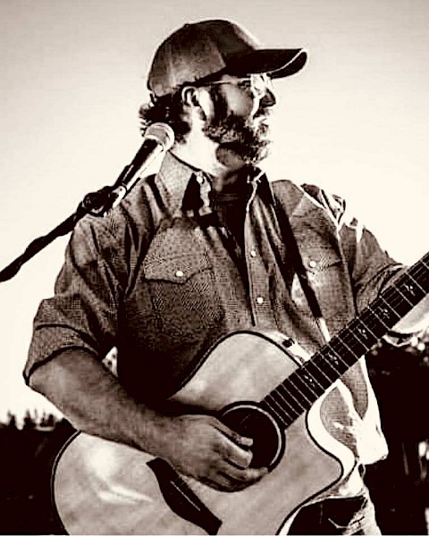 KC Flynn performing acoustic guitar during Beats & Bites Brunch at Riverhouse Lodge in Bend Oregon with guests enjoying brunch.