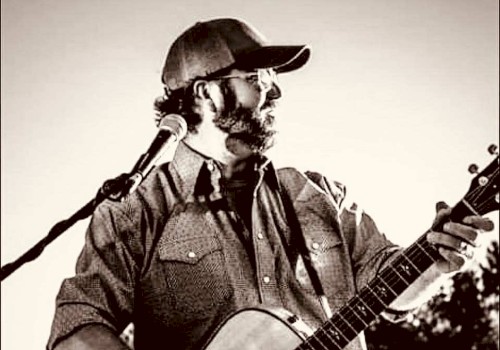 KC Flynn performing acoustic guitar during Beats & Bites Brunch at Riverhouse Lodge in Bend Oregon with guests enjoying brunch.