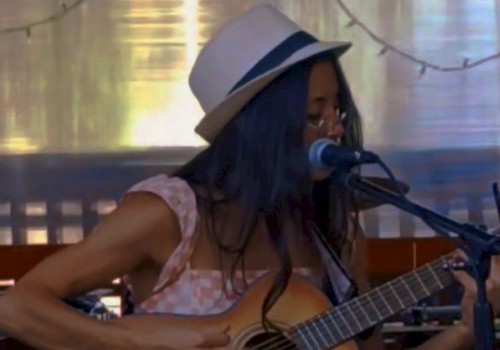 Bre Gonzalez singing and playing acoustic guitar during Beats & Bites Brunch at Riverhouse Lodge Bend Oregon.