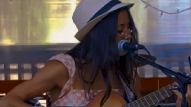 Bre Gonzalez singing and playing acoustic guitar during Beats & Bites Brunch at Riverhouse Lodge Bend Oregon.