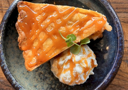 Freshly baked Grandma’s Apple Pie à la Mode with Granny Smith apples, flaky handmade crust, vanilla ice cream from Eberhardt’s Dairy, and caramel drizzle served at Riverhouse Lodge in Bend, Oregon for National Pi Day.