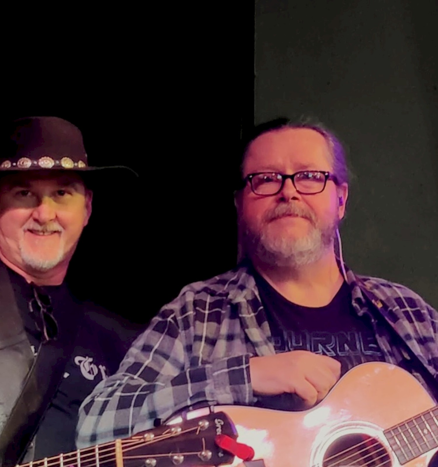 Two musicians playing acoustic guitars during a live performance at Currents Restaurant & Lounge at Riverhouse Lodge in Bend, Oregon.