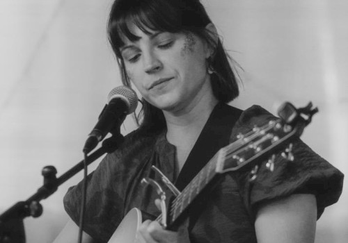 Acoustic folk singer Cecilia Voss performing live guitar music at Currents Restaurant during Live Music Friday at Riverhouse Lodge in Bend Oregon.