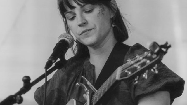 Acoustic folk singer Cecilia Voss performing live guitar music at Currents Restaurant during Live Music Friday at Riverhouse Lodge in Bend Oregon.