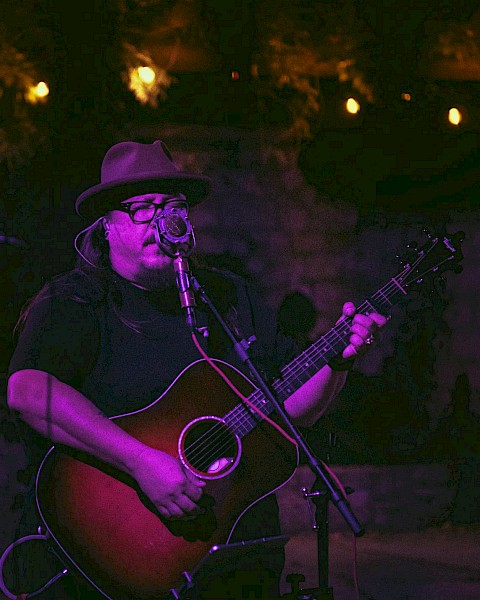 Americana singer songwriter Rudolf Korv performing acoustic guitar live at Currents Restaurant during Live Music Friday at Riverhouse Lodge Bend Oregon.