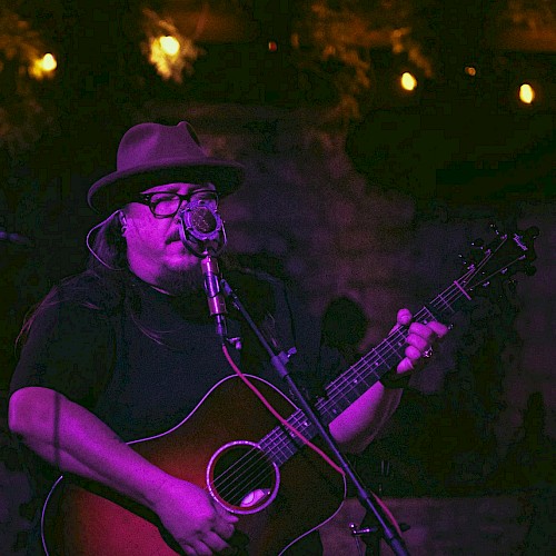 Americana singer songwriter Rudolf Korv performing acoustic guitar live at Currents Restaurant during Live Music Friday at Riverhouse Lodge Bend Oregon.