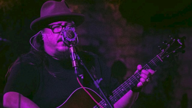 Americana singer songwriter Rudolf Korv performing acoustic guitar live at Currents Restaurant during Live Music Friday at Riverhouse Lodge Bend Oregon.