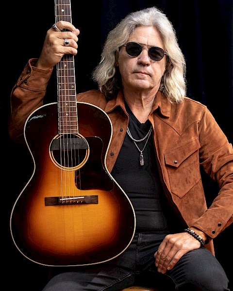 Americana singer songwriter Dean Mueller performing acoustic guitar during Beats and Bites brunch at Riverhouse Lodge Bend Oregon.