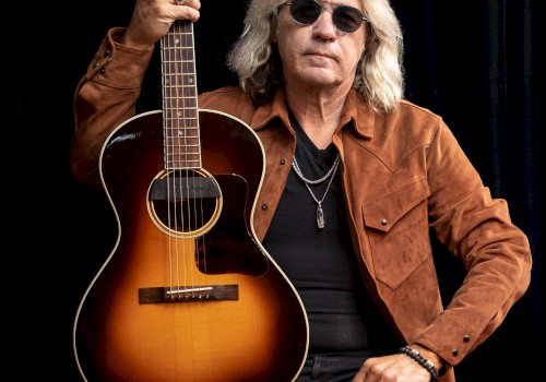 Americana singer songwriter Dean Mueller performing acoustic guitar during Beats and Bites brunch at Riverhouse Lodge Bend Oregon.