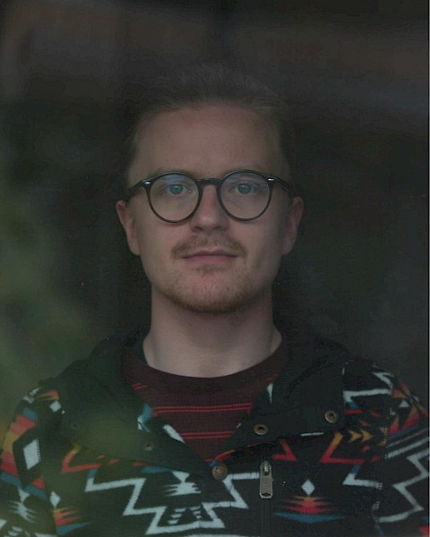 Male musician with glasses performing live acoustic set during brunch inside Currents restaurant in Bend Oregon