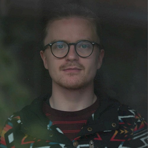 Male musician with glasses performing live acoustic set during brunch inside Currents restaurant in Bend Oregon