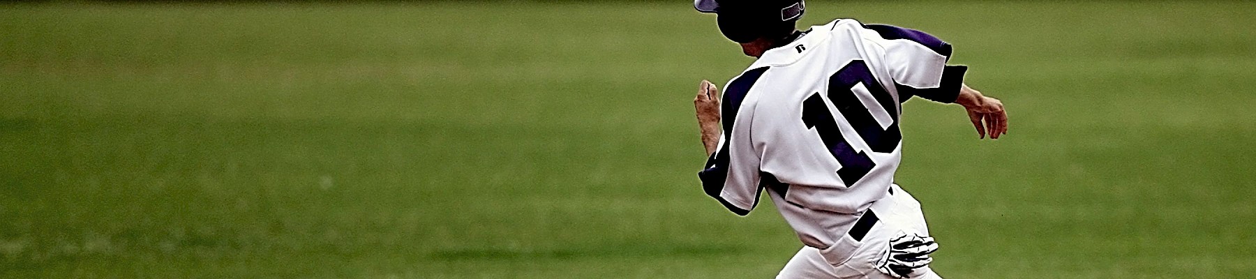 A baseball player wearing a white uniform with the number 10 is running on the field during a game.