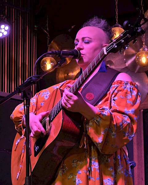 Gina DeNoble performing live acoustic folk music during Beats & Bites Brunch at Currents Restaurant in Bend Oregon