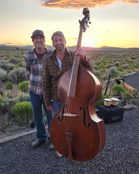 StringBenders musicians posing outdoors with upright bass at sunset in Central Oregon.