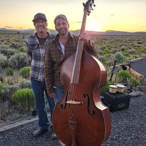 StringBenders musicians posing outdoors with upright bass at sunset in Central Oregon.