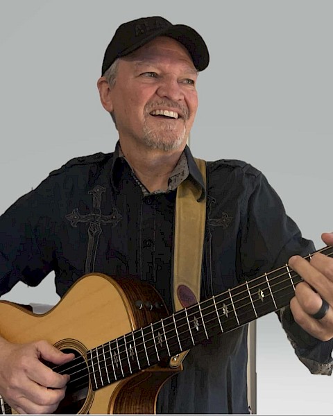 Dirk Benson performing live acoustic guitar music during a solo set in Bend, Oregon.