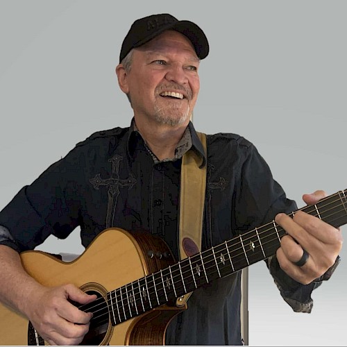 Dirk Benson performing live acoustic guitar music during a solo set in Bend, Oregon.