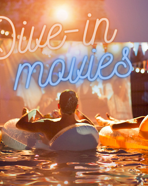 People are watching a movie from the pool with the sign 