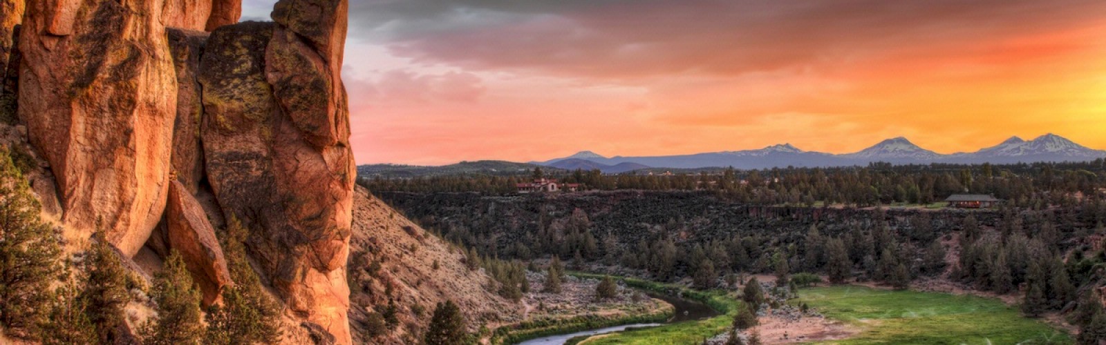 The image shows a scenic landscape with a towering rock formation, a winding river, lush greenery, and a vibrant sunset with colorful skies.