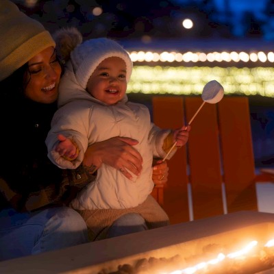 Family roasting marshmallows by a fire pit at Riverhouse Lodge in Bend, Oregon, enjoying a cozy evening together on their Central Oregon family vacation.