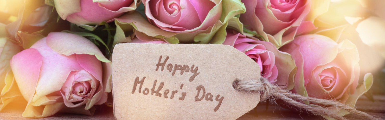 A bouquet of pink roses with a tag saying 