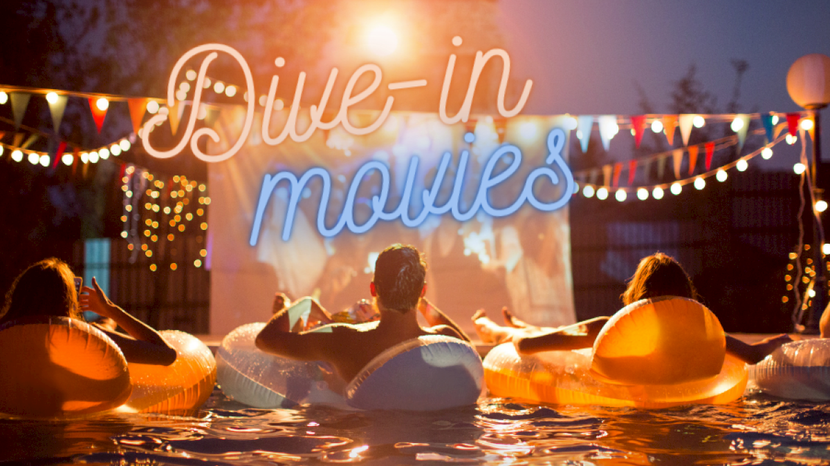 People are floating in the pool at Riverhouse Lodge located in Bend, Oregon, on inflatable rings, watching a movie on a screen under a sign that reads 