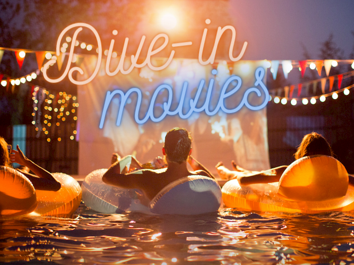 People are floating in the pool at Riverhouse Lodge located in Bend, Oregon, on inflatable rings, watching a movie on a screen under a sign that reads 