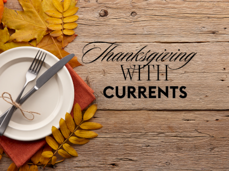 A Thanksgiving-themed setting with a plate, utensils, leaves, and a pumpkin on a wooden table. Text reads 