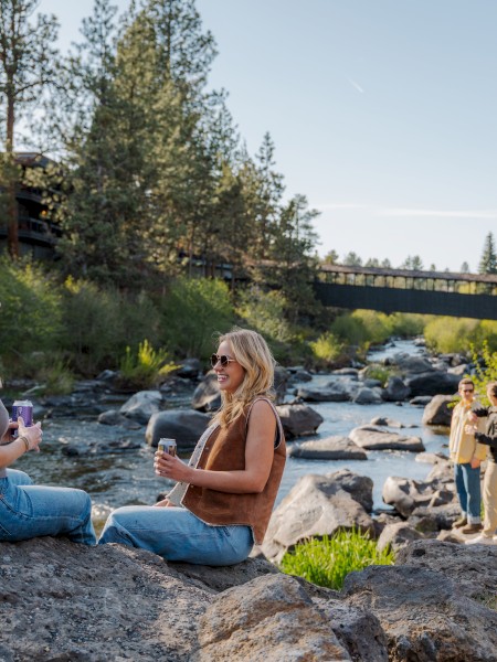 Guests relax by the Deschutes River at Riverhouse Lodge, just minutes from River’s Edge Golf Course—ideal for a scenic and restful golf getaway in Bend, Oregon