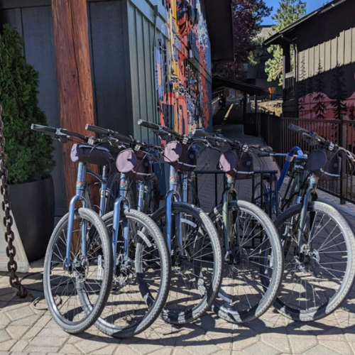Bike rentals lined up outside Riverhouse Lodge, ready for guests to explore scenic trails and riverfront paths in Bend, Oregon.