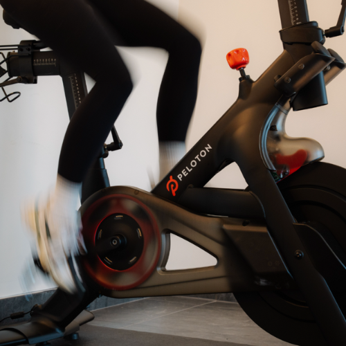 Guest riding a Peloton bike in the Riverhouse Lodge fitness center—ideal for a high-energy indoor cycling session during your Bend stay.