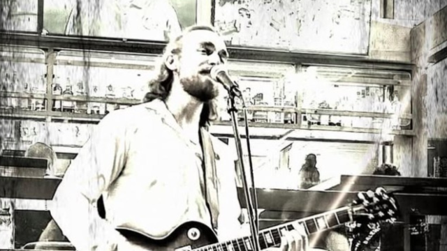 Jordan Madsen is playing a guitar and singing into a microphone in a stylized, sepia-toned setting. Free Live Music at Riverhouse Lodge in Bend Oregon 08/15/25
