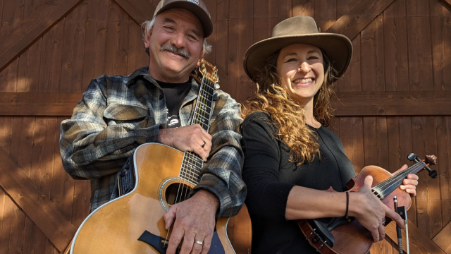 Two Americana singer-songwriters holding acoustic guitar and violin during a live brunch performance at Currents at Riverhouse Lodge, a riverfront live music venue in Bend, Oregon.