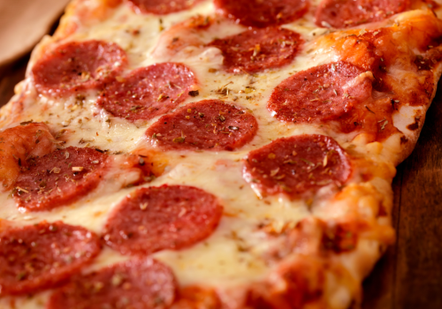 $10 flatbread pizza with pepperoni slices and melted cheese on a wooden board at Currents at Riverhouse in Bend Oregon July 28