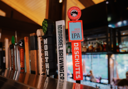 A variety of beer tap handles, including one for Deschutes Fresh Squeezed IPA, is displayed in Currents at Riverhouse in Bend, Oregon with $5 beer specials on Sundays for NFL