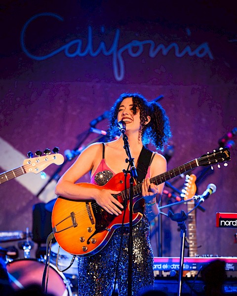 Rebecca Conner live music performance in Bend Oregon at Currents at the Riverhouse, playing guitar on stage with band equipment, September 12 2025 concert near the Deschutes River
