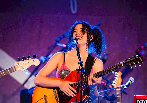 Rebecca Conner live music performance in Bend Oregon at Currents at the Riverhouse, playing guitar on stage with band equipment, September 12 2025 concert near the Deschutes River
