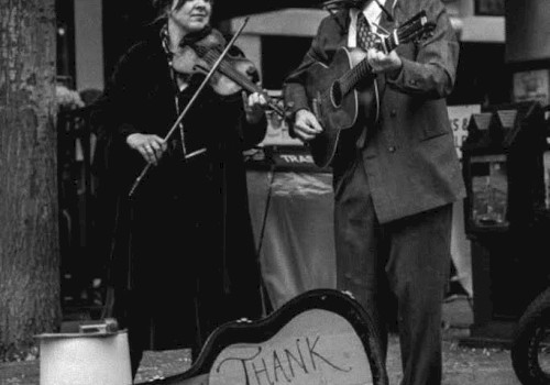Black-and-white photo of two musicians performing live outdoors, featuring fiddle, guitar, harmonica, and vocals. Lickety Split brings Americana, old-time, and roots-inspired music to Riverhouse Lodge's Live Music Friday event in Bend, Oregon.