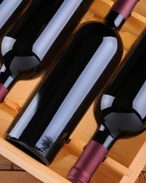 Wine bottles in a wine crate shown for Currents Locals Week with 10% off Wine by the Bottle