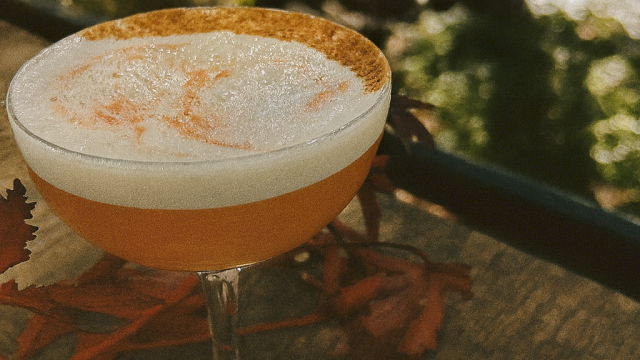 Golden Hour Sour cocktail with maple, bourbon, and cinnamon foam served on the riverside patio at Currents at Riverhouse Lodge in Bend Oregon during golden hour light.